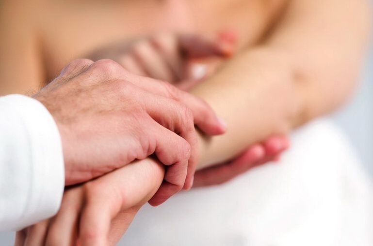 Dermatolog pregleduje bolnika z luskavico